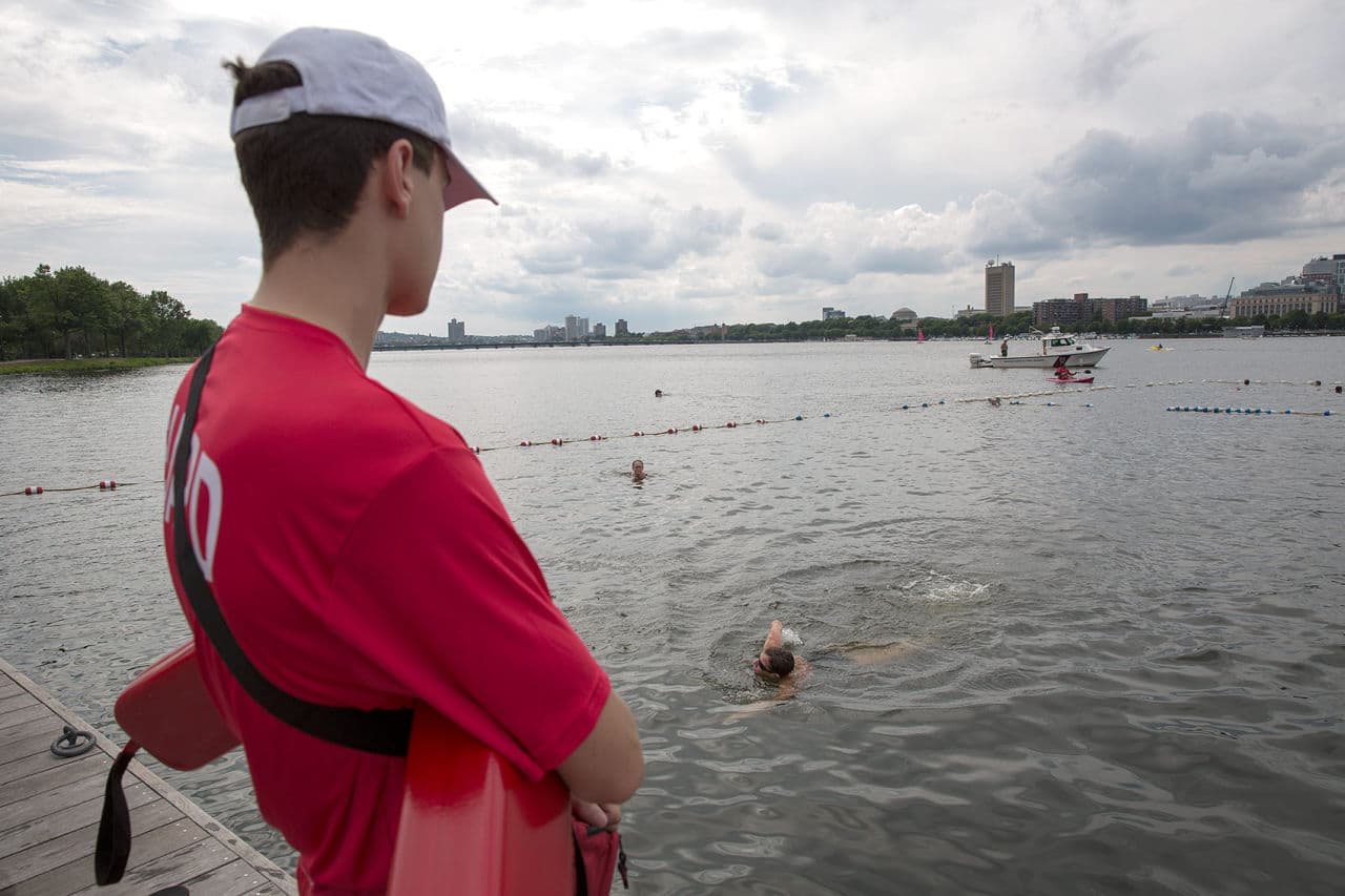 DCR lifeguard Loic Sanges watches over people swimming in the Charles on the first of two days this year when residents will be able to swim in the river. (Robin Lubbock/WBUR)