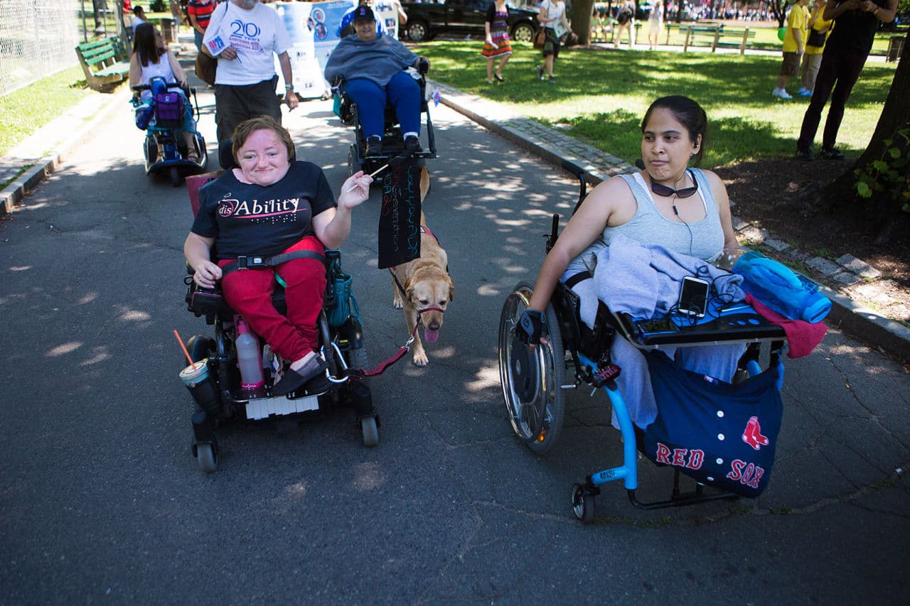 Desi Forte and Michelle Whitney march through Boston Common to celebrate 25 years since the passing of the Americans with Disabilities Act. (Jesse Costa/WBUR)