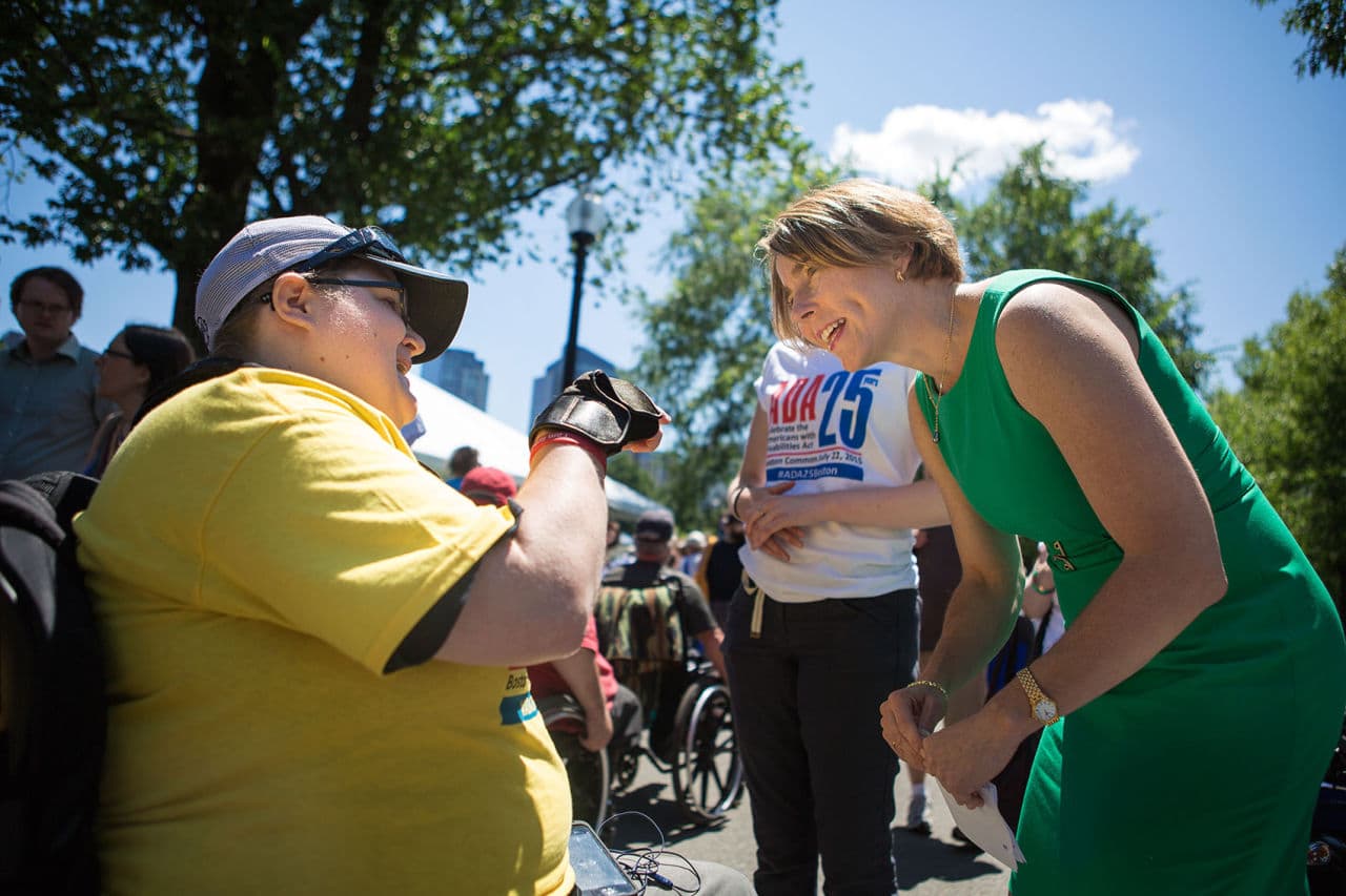 A former basketball player, Attorney General Maura Healey got an invitation to play wheelchair basketball from a woman volunteering at the celebration. (Jesse Costa/WBUR)