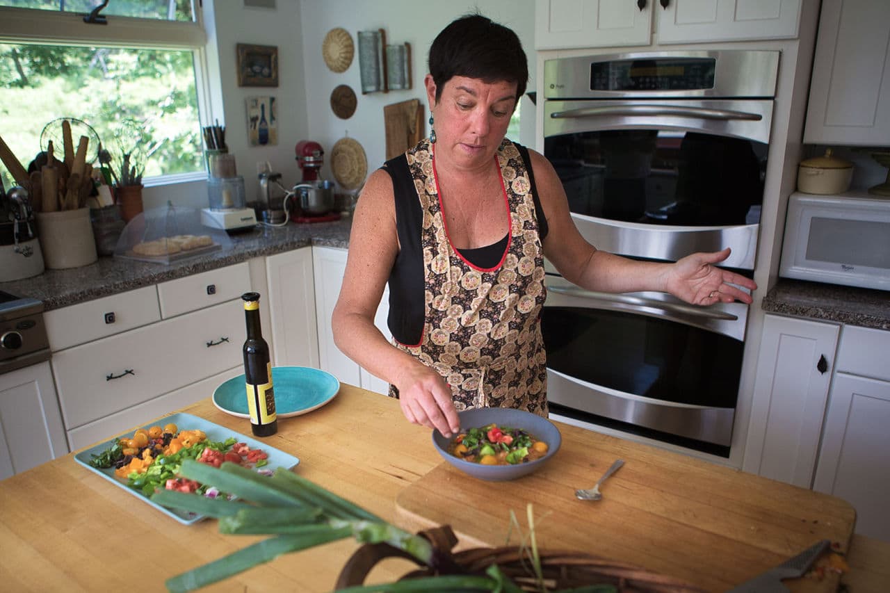 Kathy garnishes the gazpacho. (Jesse Costa/WBUR)