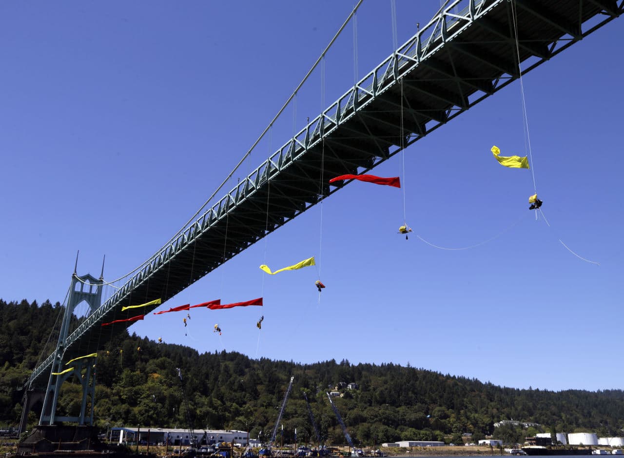 Activists unfurl colored banners while hanging from the St. Johns bridge in Portland, Ore. on Wednesday to protest the departure of Royal Dutch Shell PLC icebreaker Fennica, which is in Portland for repairs. (Don Ryan/AP)
