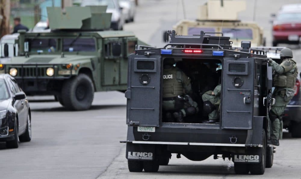 A SWAT team drives through a Watertown neighborhood in April 2013 while searching for a suspect in the Boston Marathon bombings. (Charles Krupa/AP)