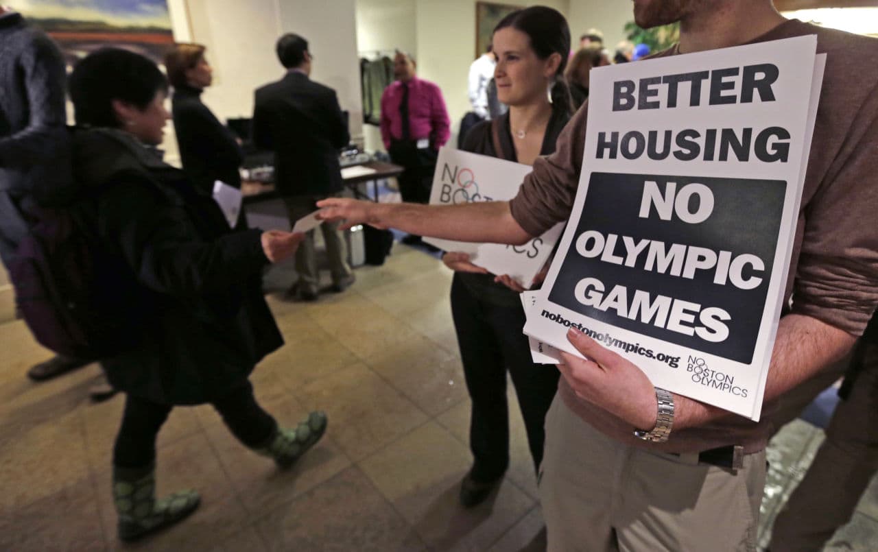 Opponents to Boston's Olympic bid hand out fliers in February prior to the first public forum regarding the bid. (Charles Krupa/AP)