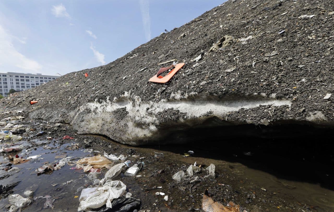 On May 28, debris covered the lingering snow pile. The city said it had pilled 85 tons of debris from the pile at that point. (Elise Amendola/AP)
