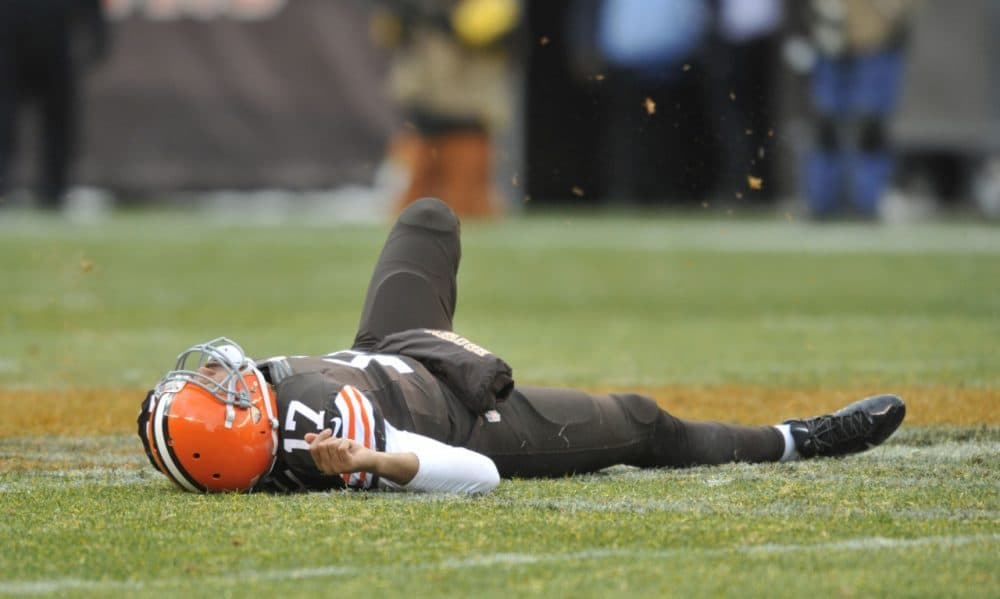 Cleveland Browns QB Jason Campbell lies near midfield after suffering a concussion in a game on Nov. 24, 2013. Traumatic brain injuries, whether they occur on a sports field or in a war zone, are on the rise. (David Richard/AP)