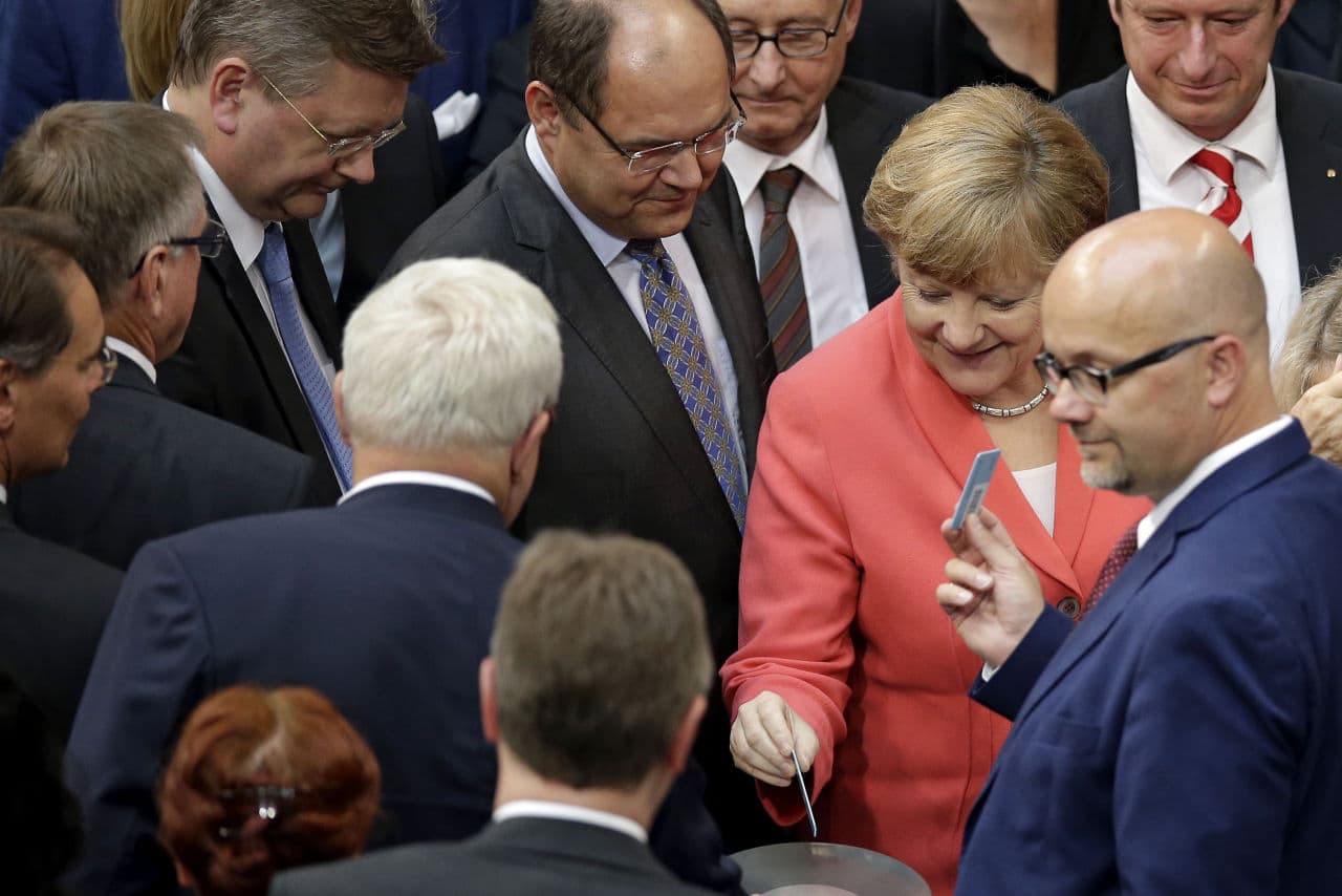 German Chancellor Angela Merkel, second right, casts her vote during a meeting of the German federal parliament, Bundestag, in Berlin, Germany, Friday, July 17, 2015. German lawmakers are voting on a third bailout package for Greece later on Friday. (AP)