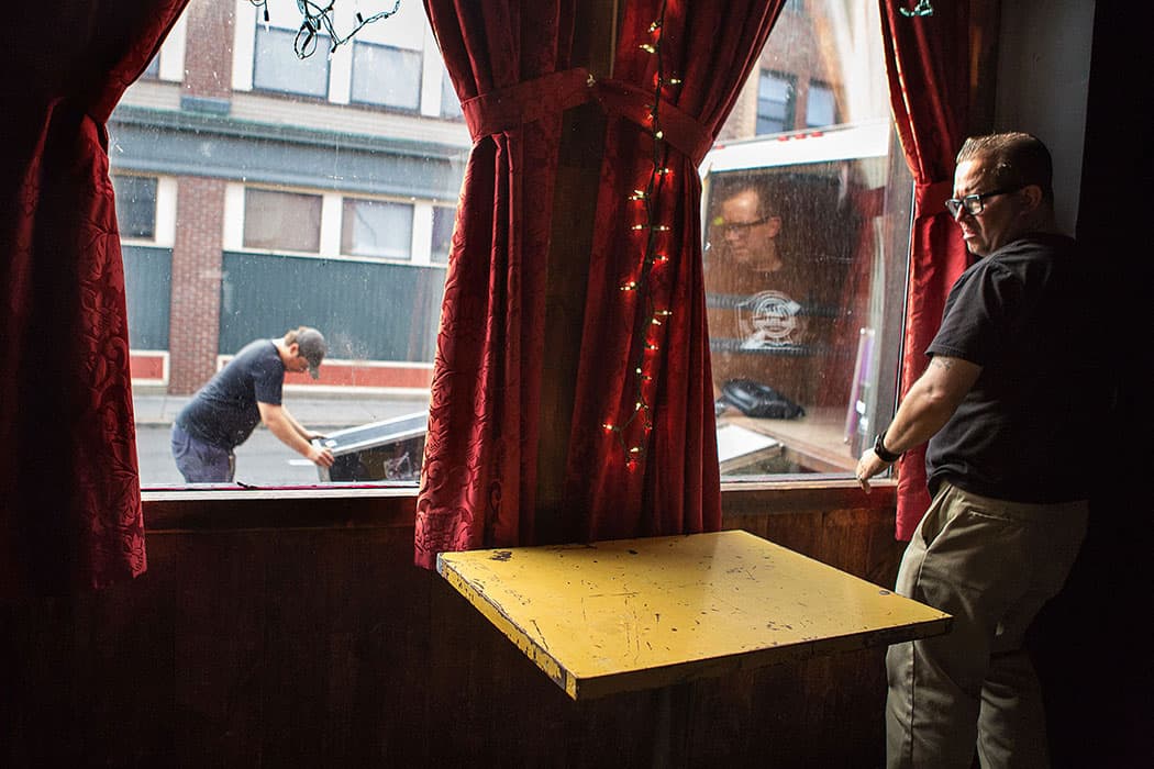 T.T. the Bear’s manager Kevin Patey pulls open the curtains preparing to open on a recent night as sound equipment is being loaded in. (Jesse Costa/WBUR)