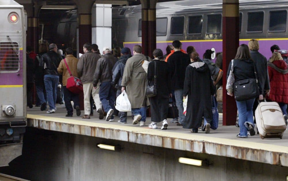 Holiday travelers walk to board a train at the South Station in Boston. (Bizuayehu Tesfaye/AP)
