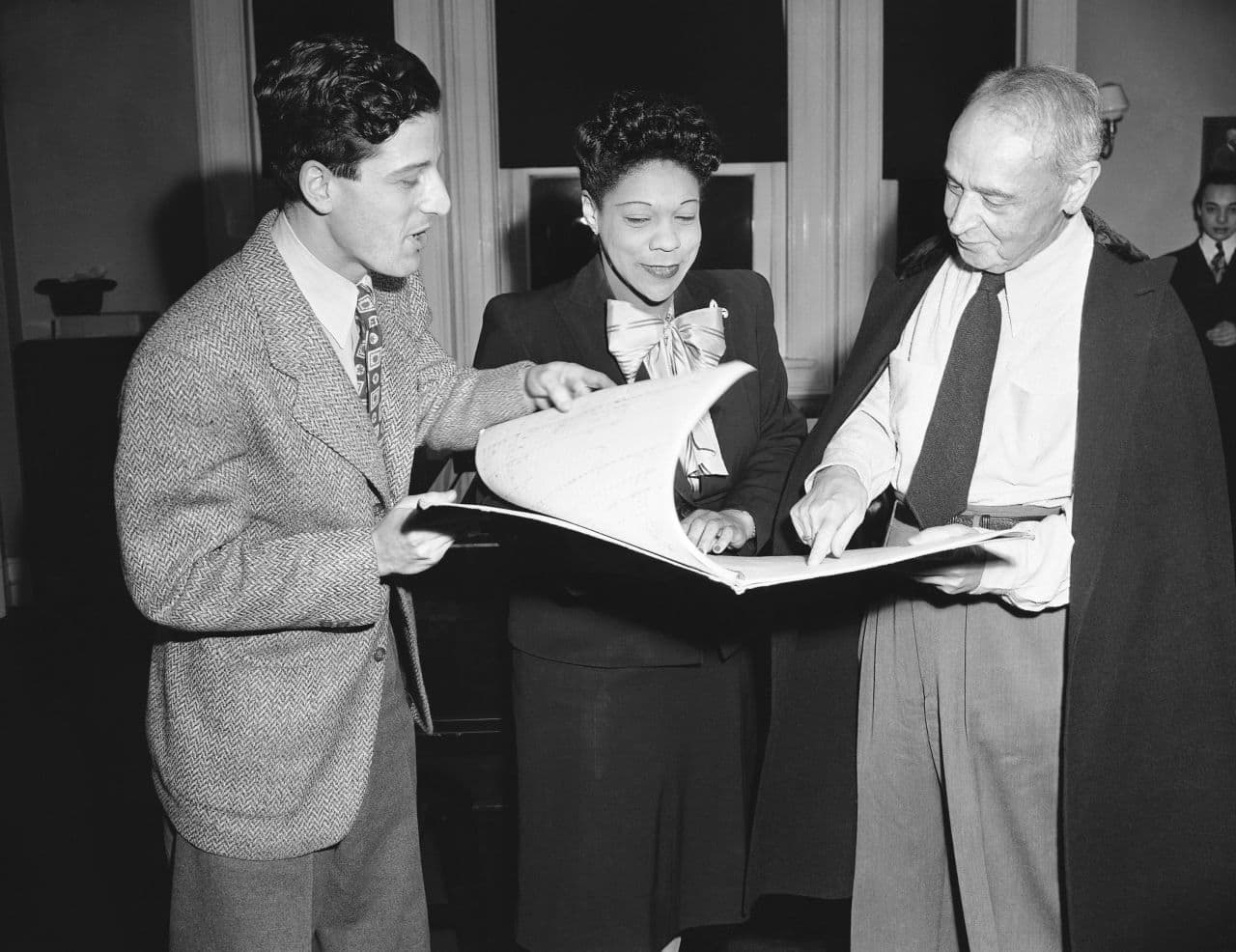 From left to right: Lukas Foss, at age 24, Ellabelle Davis and Serge Koussevitzky go over the score of a cantata composed by Foss, pianist with the orchestra to be sung by Miss Davis. (AP Photo/FCC)