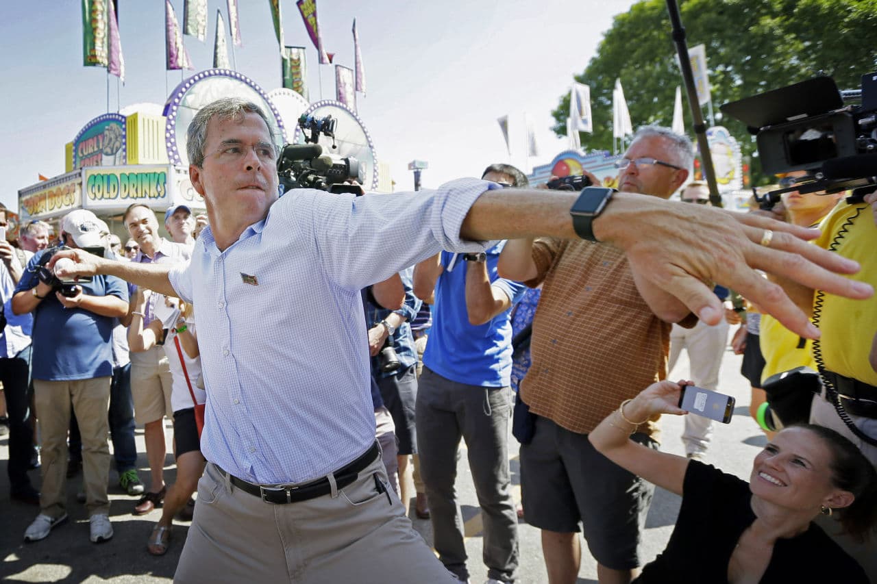Republican presidential candidate Jeb Bush throws a baseball on the midway during a visit to the Iowa State Fair Friday. (Charlie Neibergall/AP)