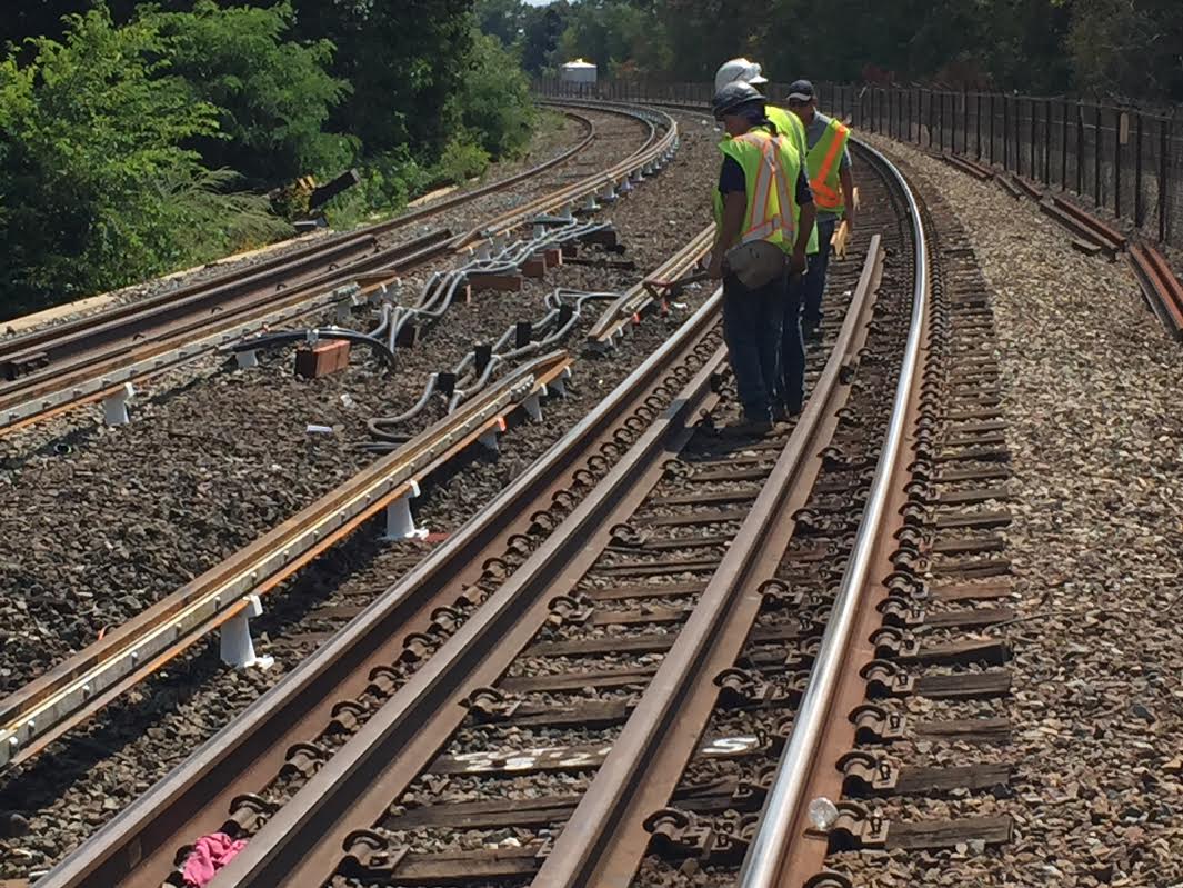 Workers inspect new third rails on a stretch of the Red Line between JFK/UMass and North Quincy stations. (Jack Lepiarz/WBUR)