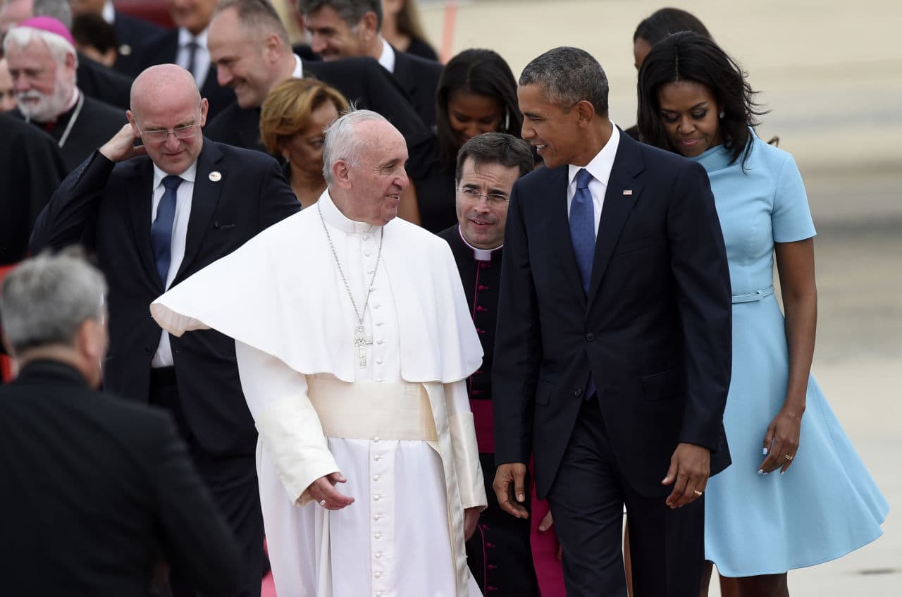 Pope Francis talks with President Barack Obama, accompanied by first lady Michelle Obama, after arriving at Andrews Air Force Base in Md., on Tuesday. (Susan Walsh/AP)