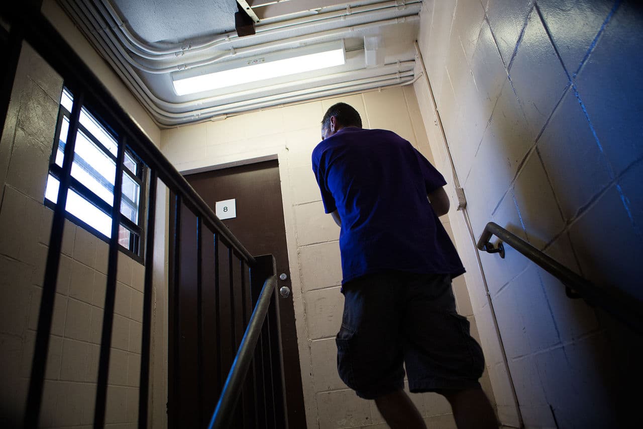 Joey walking up the stairs in the apartment building where he lives. (Jesse Costa/WBUR)
