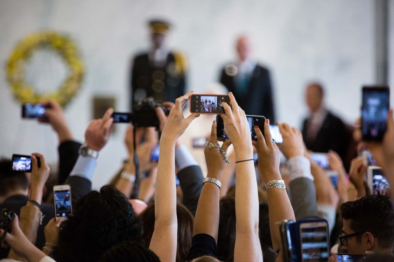 UN personnel take photos as Pope Francis arrives to greet the staff members at United Nations headquarters with Secretary General Ban Ki-moon Friday, Sept. 25, 2015. The Pope will address the UN General Assembly. (Kevin Hagen/AP)