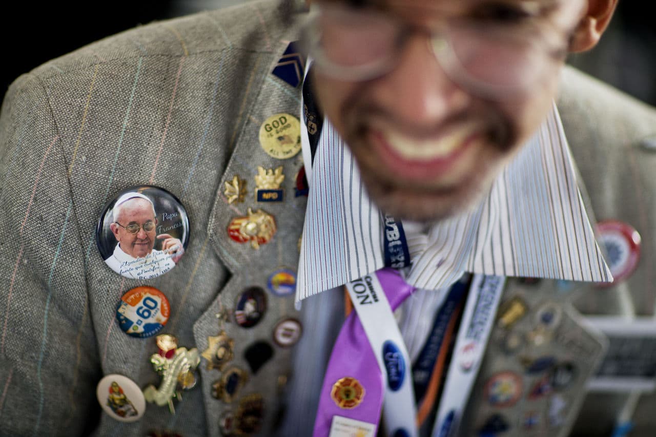 Mark Perez wears buttons, including one bearing the image of Pope Francis while waiting for him to arrive at the Catholic Charities of the Archdiocese of Washington, Thursday, Sept. 24, 2015. When asked what he plans to say to the Pope, Perez replied, "Stay blessed and not stress, that's my slogan." (David Goldman/AP)