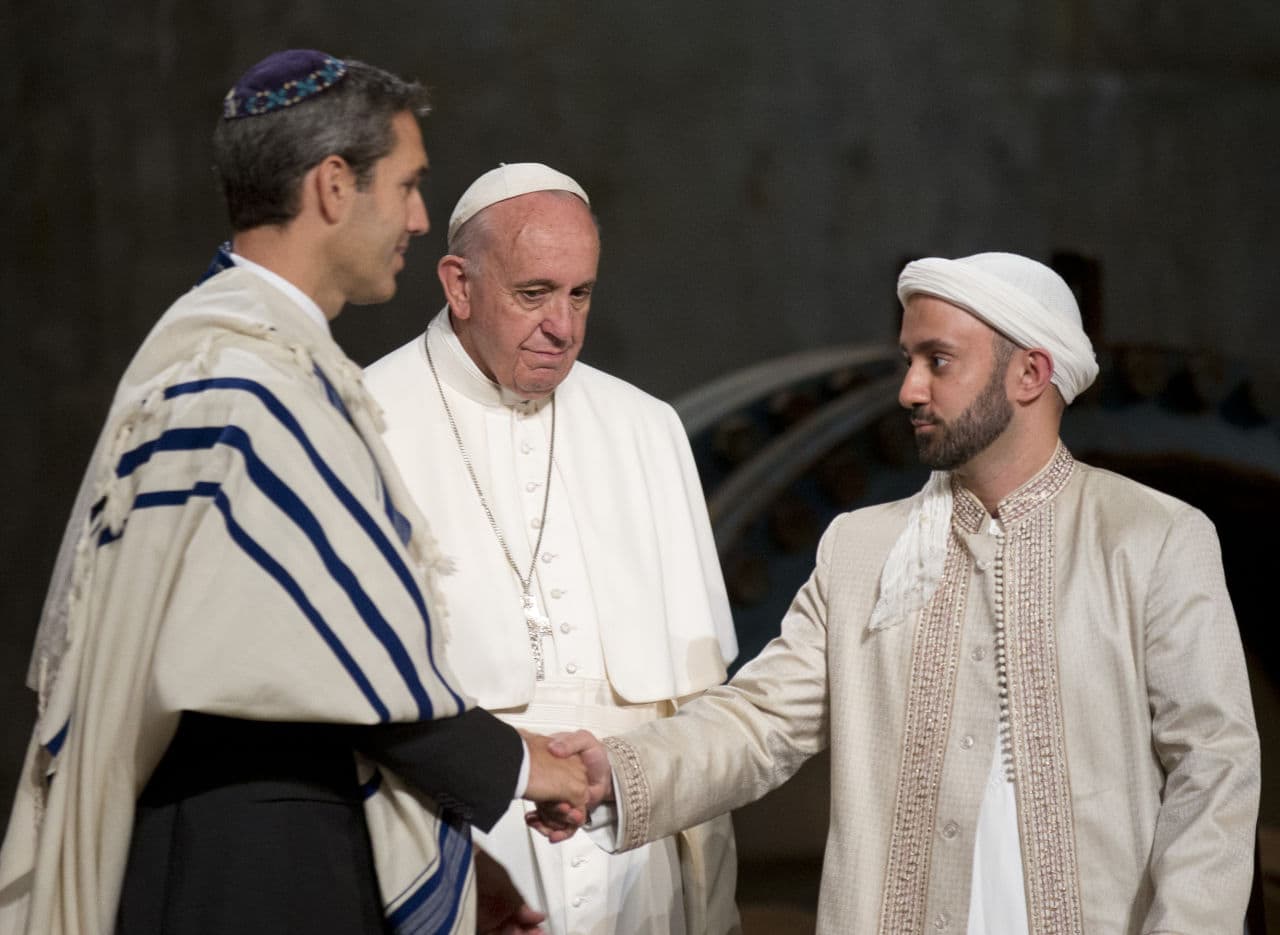 Pope Francis looks at Imam Khalid Latif, right, and Rabbi Elliot J. Cosgrove, left, shaking hands as he arrives for an interfaith service at the Sept. 11 memorial museum in New York, Friday Sept. 25, 2015. (Alessandra Tarantino/AP)