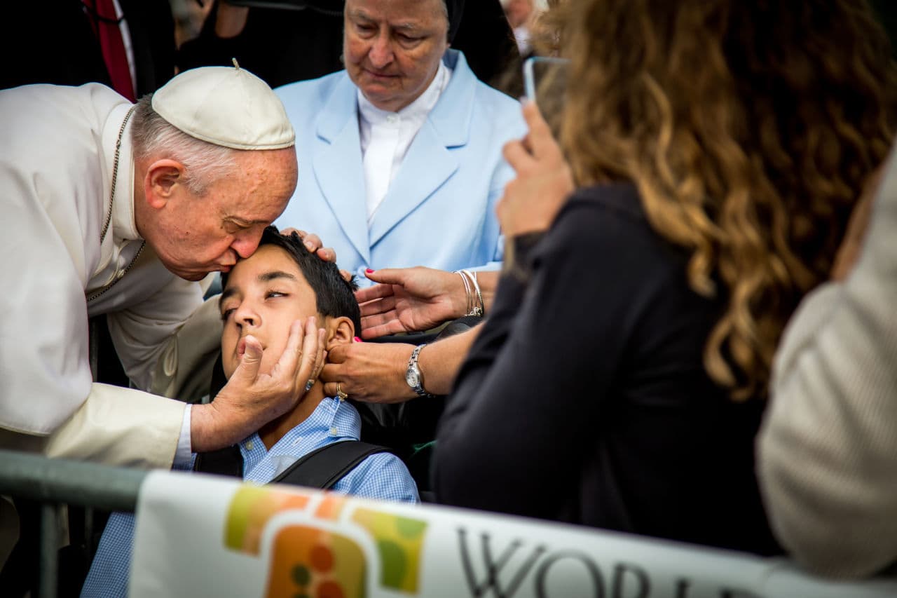 Pope Francis kisses and blesses Michael Keating, 10, of Elverson, Pa after arriving in Philadelphia and exiting his car when he saw the boy, Saturday, Sept. 26, 2015, at Philadelphia International Airport. Keating has cerebral palsy and is the son of Chuck Keating, director of the Bishop Shanahan High School band that performed at Pope Francis' airport arrival. (Joseph Gidjunis/World Meeting of Families via AP)