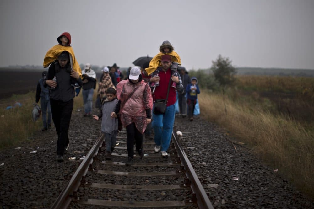 Syrian refugees walk on a railway track toward a makeshift camp for asylum seekers in southern Hungary Thursday. (Muhammed Muheisen/AP)