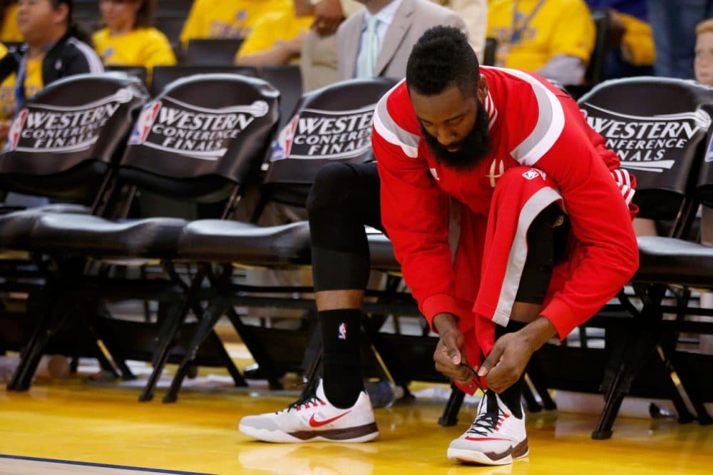 Houston Rockets gaurd James Harden laces up his Nike sneakers in preparation for a game last season.  He'll be donning a different pair when the season opens in October. 