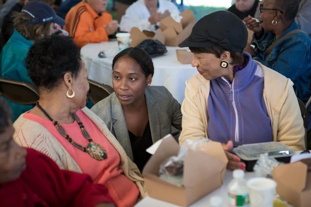 Andrea Campbell, center, spoke with seniors at a cookout in Boston's Harambee Park Wednesday. She's attempting to unseat Councilor Charles Yancey. (Jesse Costa/WBUR)