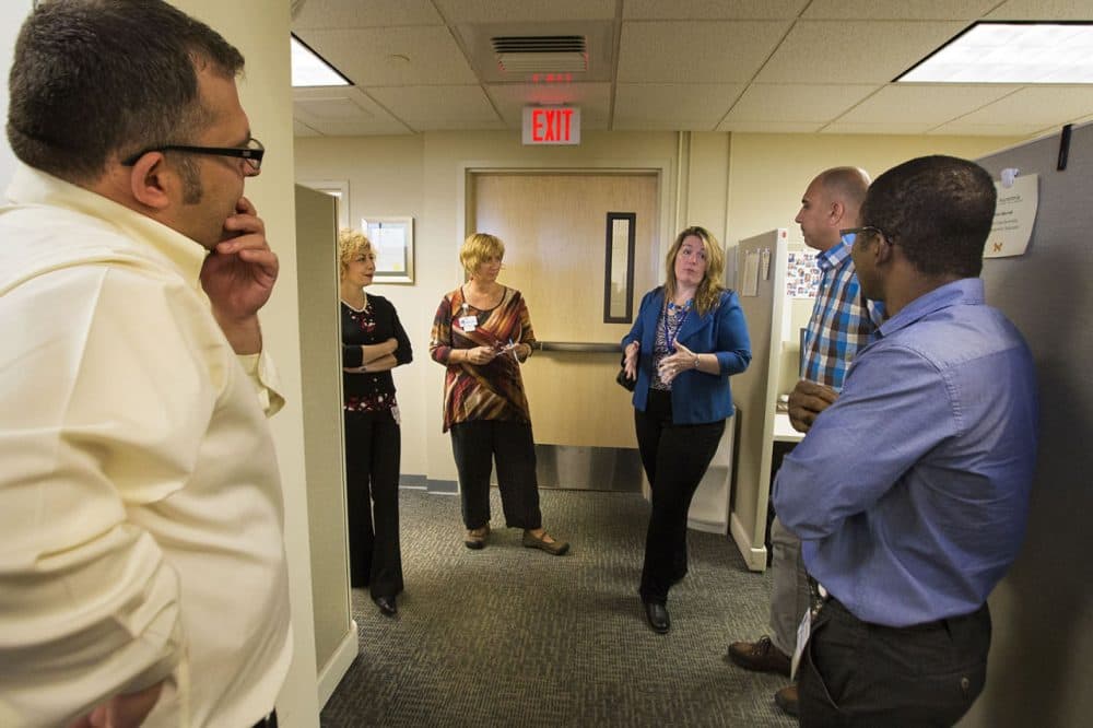 Ascentria CEO Angela Bovill speaks with her team during a visit to the Worcester office. (Jesse Costa/WBUR)