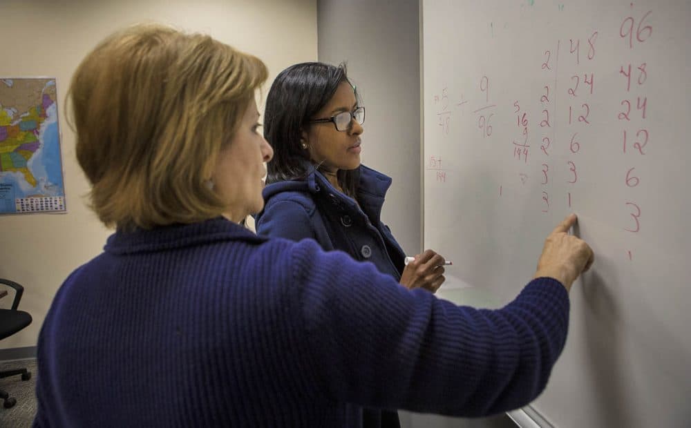 Ascentria math instructor Hadil Sarsam goes through an classroom exercise with Simone Alameda, of Brazil. (Jesse Costa/WBUR)