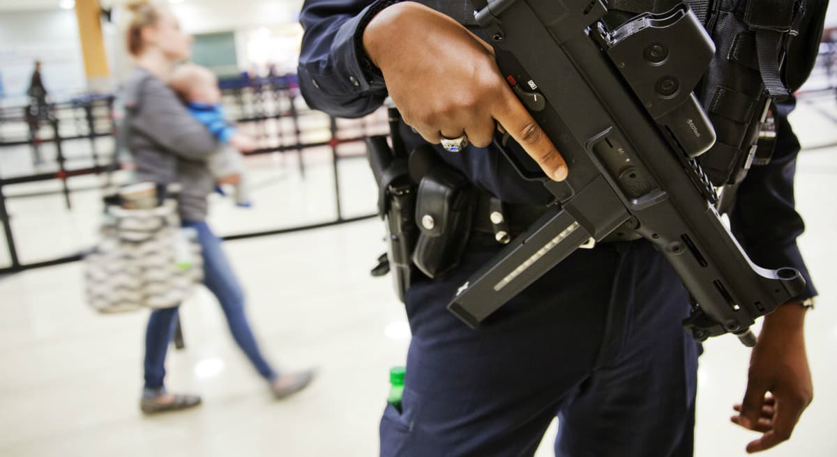Carol Rose and Kade Crockford: If we respond to the killing in Paris by turning our backs on refugees who need our help, expanding unconstitutional government power at home, or viewing our own neighbors with suspicion and hostility, we sacrifice our principles in exchange for a false sense of security. In this photo, a police officer stands guard by a security checkpoint at Hartsfield–Jackson Atlanta International Airport, Wednesday, Nov. 18, 2015, in Atlanta. (David Goldman/ AP)