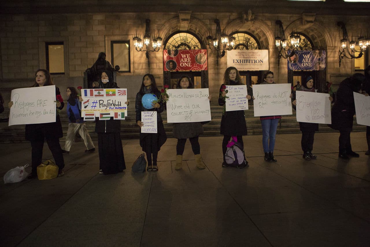 The women attending the vigil held signs promoting peace, as well as compassion for refugees. (Jesse Costa/WBUR)