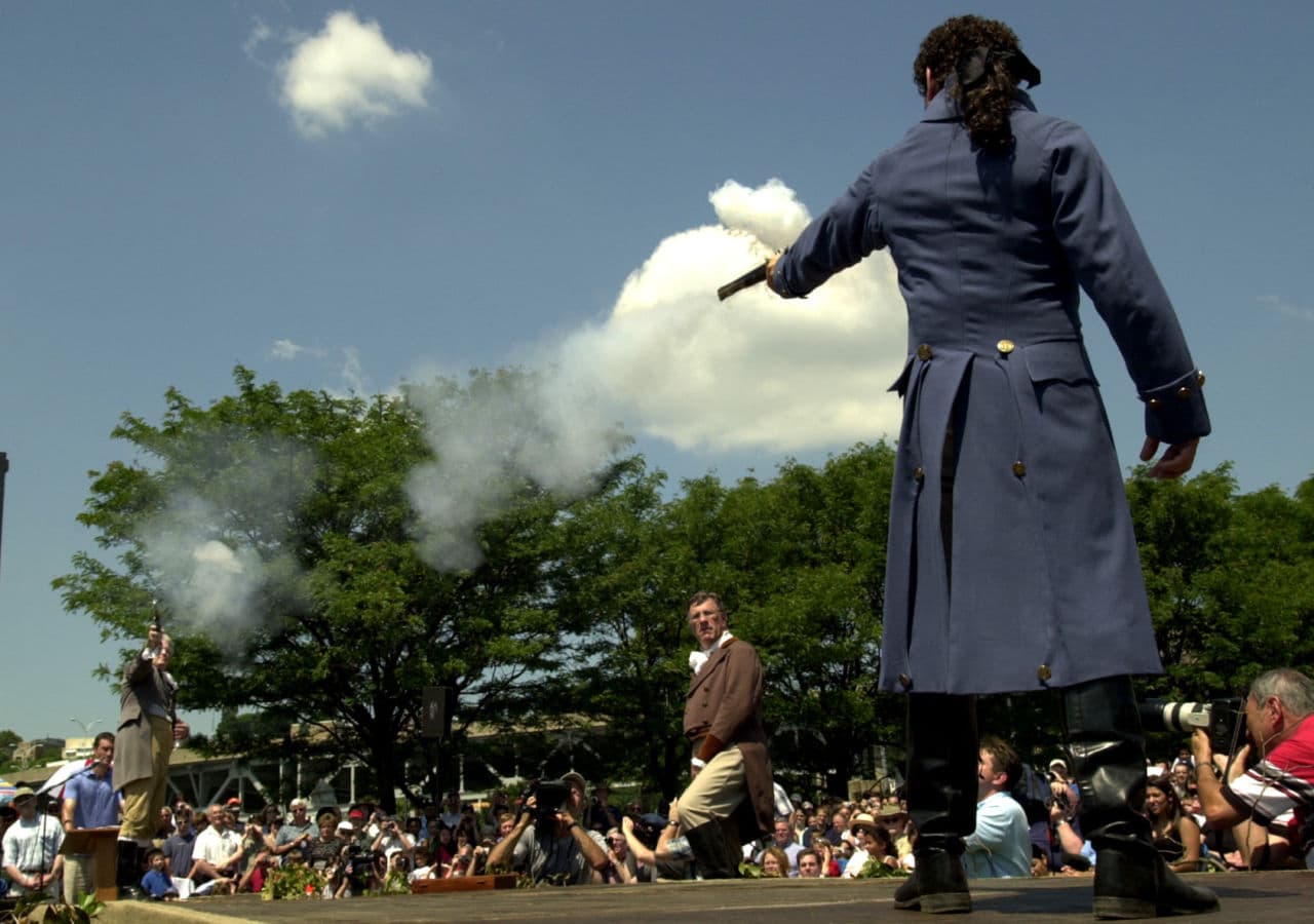 Douglas Hamilton, left, a fifth-great-grandson of Alexander Hamilton and Antonio Burr, right, a descendant of Aaron Burr's cousin, fire their pistols during the re-enactment marking the 200th anniversary of the Hamilton-Burr duel. (Marko Georgiev/AP)