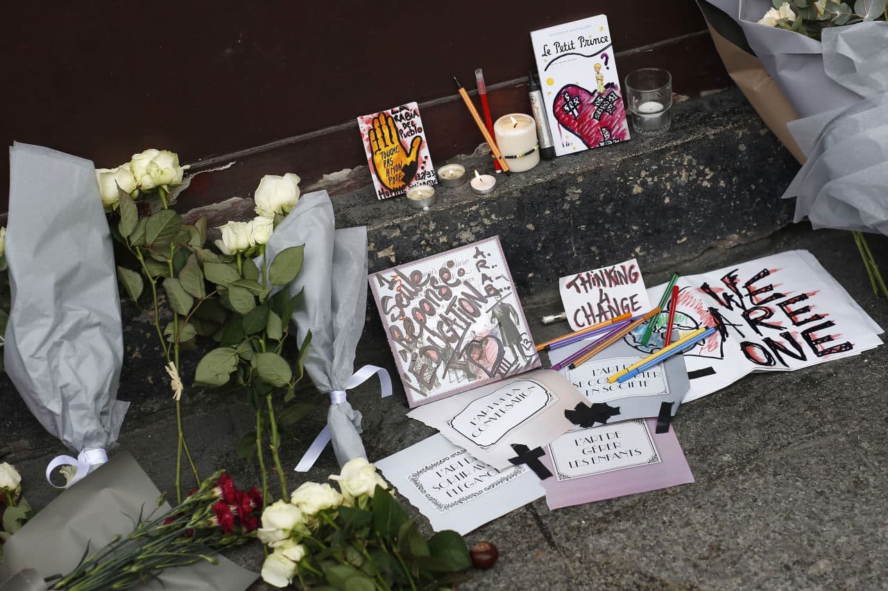 Cards, candles and flowers are placed in front of the Carillon cafe in Paris on Saturday, a day after dozens were reportedly killed on the sidewalks outside as other attacks took place throughout the city. (Jerome Delay/AP)