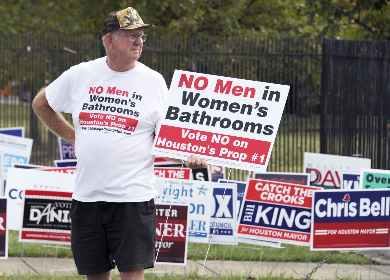 A man urges people to vote against the Houston Equal Rights Ordinance outside an early voting center in Houston on Wednesday, Oct. 21, 2015. The contested ordinance is a broad measure that would consolidate existing bans on discrimination tied to race, sex, religion and other categories in employment, housing and public accommodations, and extend such protections to gays, lesbians, bisexuals and transgender people. (AP Photo/Pat Sullivan)