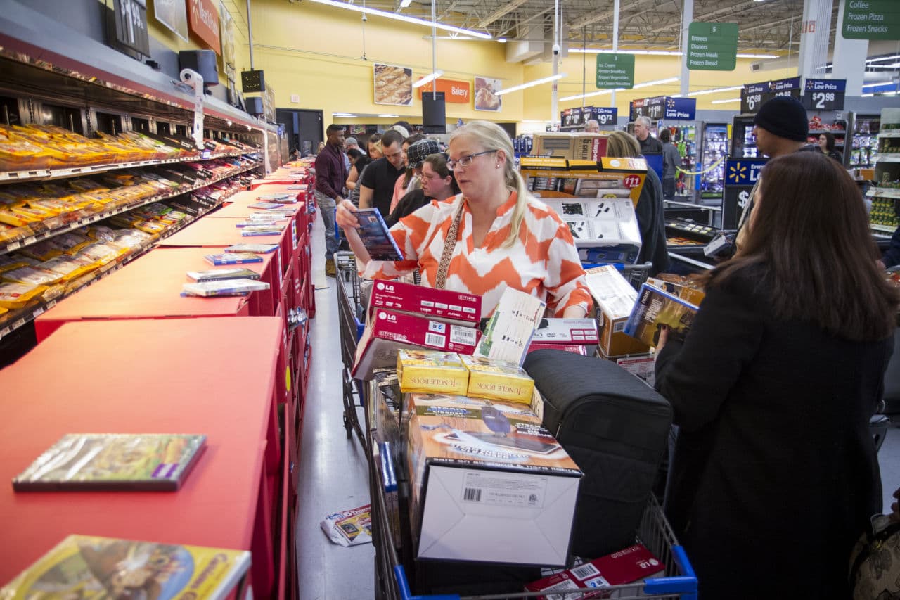 Ann Harris browses top movies in the meat section at Walmart on Thursday, Nov. 27, 2014 in Bentonville, Ark. Each Thanksgiving Walmart flips from being the nation's largest grocer to the nation's largest gift destination for Black Friday. (Gunnar Rathbun/ Invision, AP)