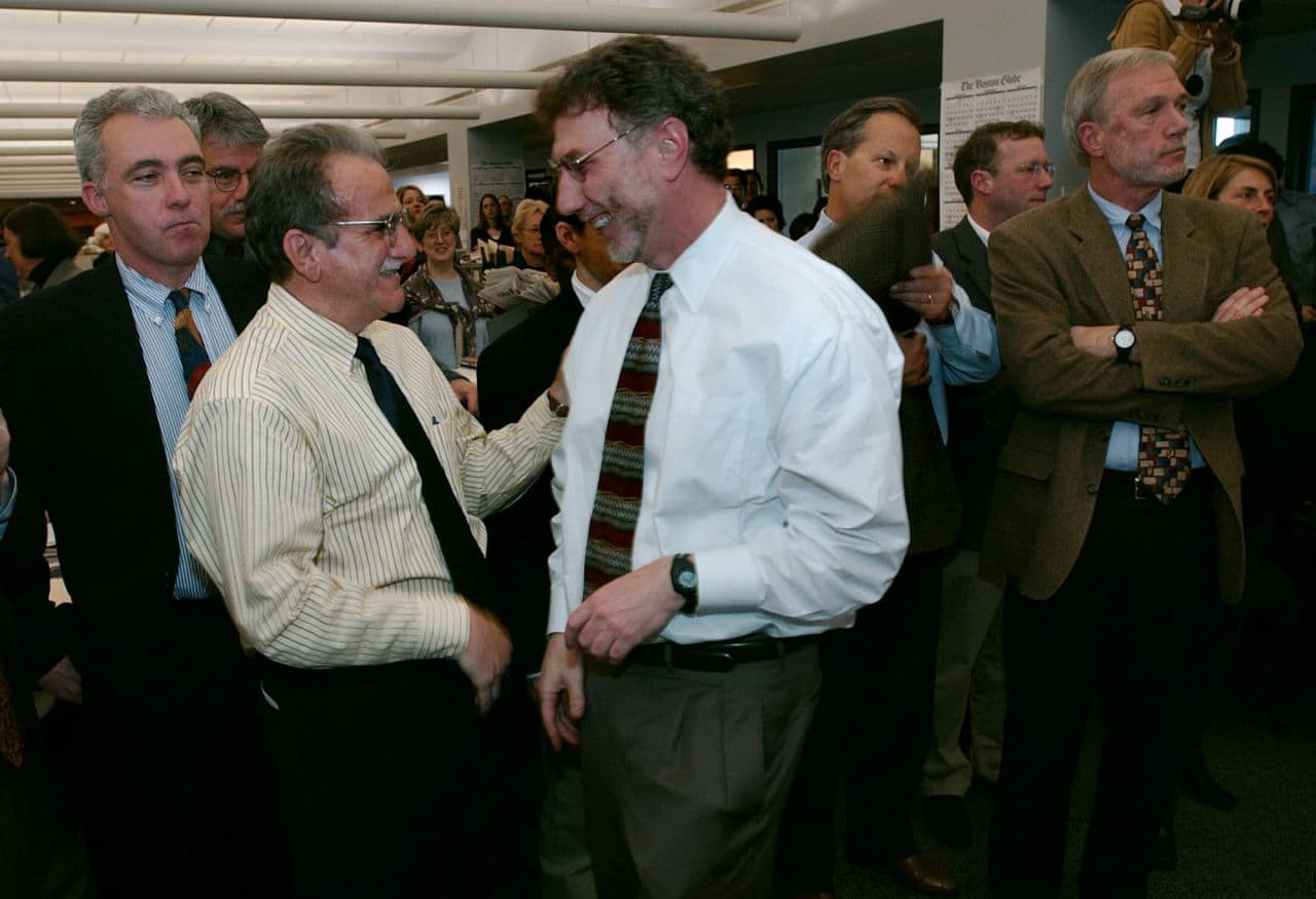 Boston Globe editor Marty Baron, center, congratulates reporter Stephen Kurkjian, second from left, after the newspaper was awarded a Pulitzer Prize in Boston, Monday April 7, 2003. The Globe was given a Pulitzer for public service for its coverage of the church abuse scandal that rocked the Boston archdiocese. From left are reporters Kevin Cullen, Kurkjian, Baron, Ben Bradlee Jr., Thomas Farragher, Walter Robinson and Sacha Pfeiffer. (AP/Charles Krupa)