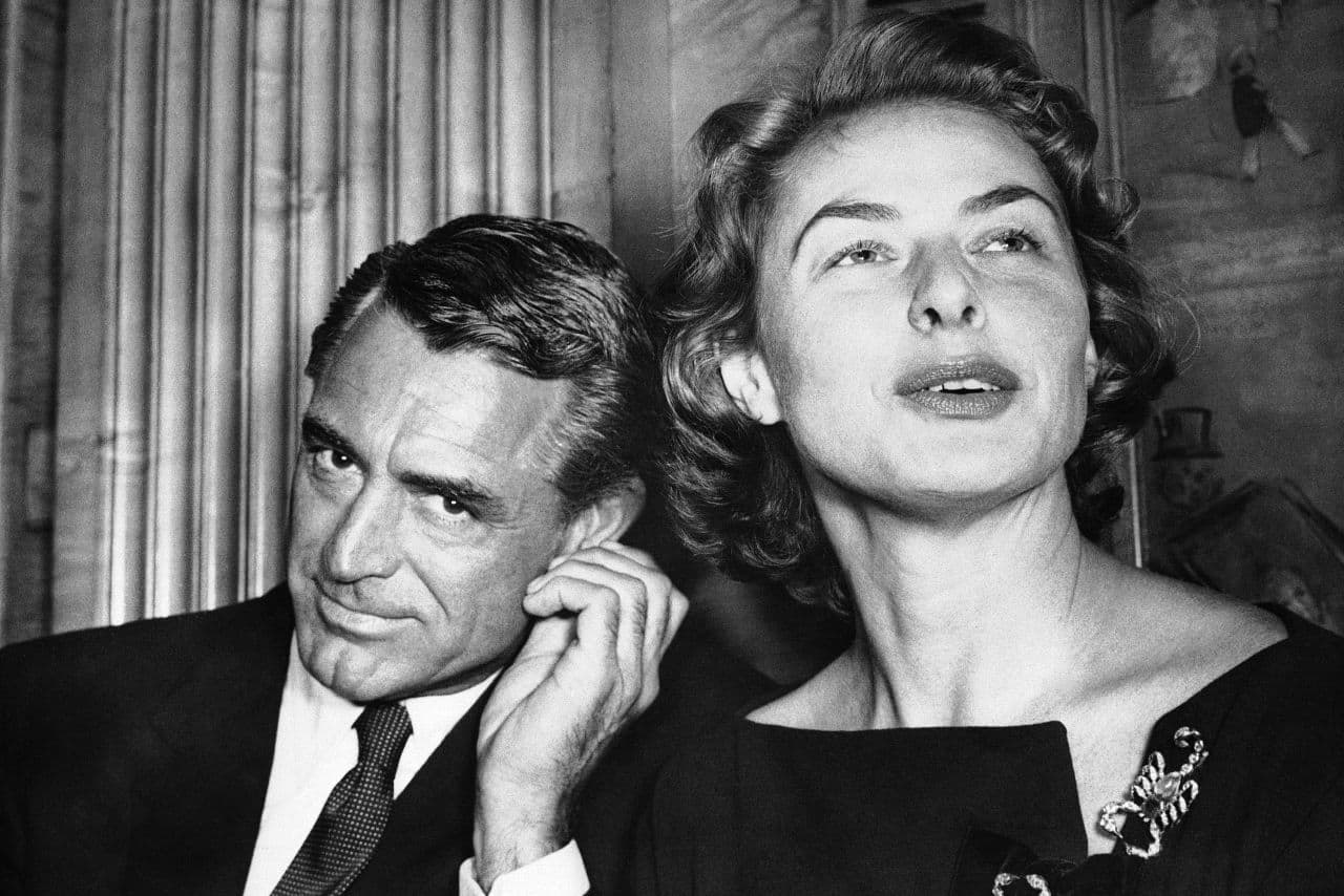 In this file photo, actress Ingrid Berman tells newsmen in London on Nov. 13, 1957 about her new picture in which she will co-star with Cary Grant, who listens to her comments. (AP)