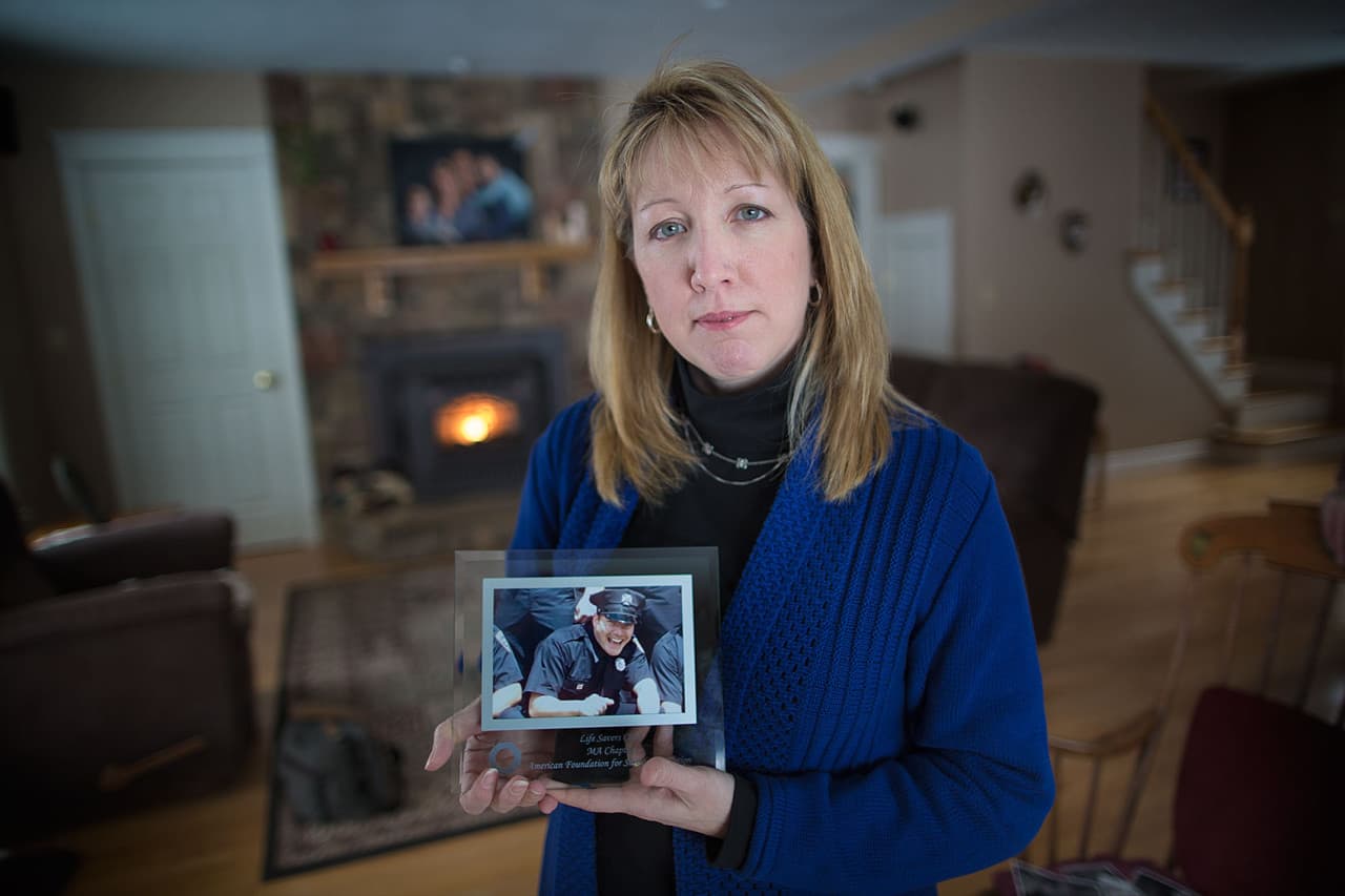 Justine Barnes holds a photo of her brother, Luke LaCaire, who died by suicide. (Jesse Costa/WBUR)