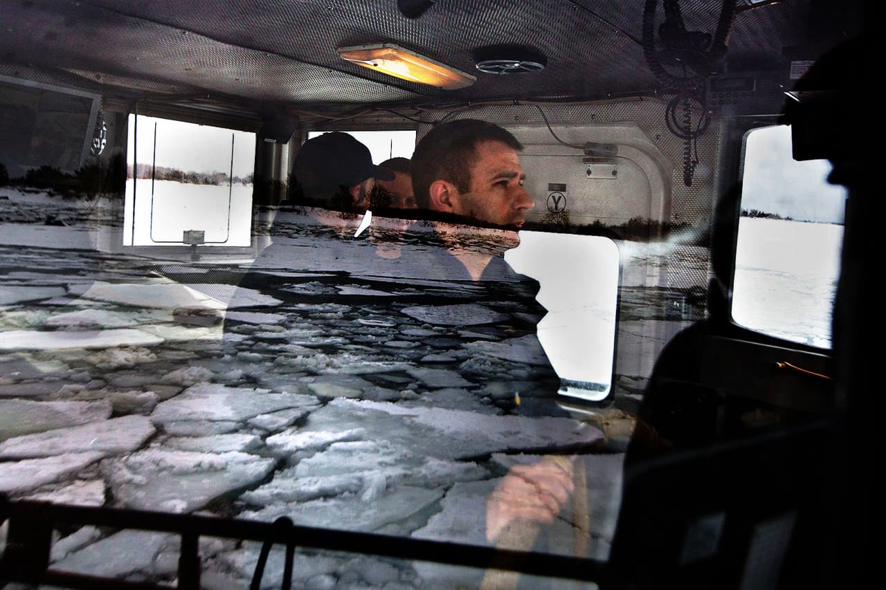 A reflection of ice in the window as Boatswain Mate Sebastian Derda maneuvers the USC Bollard through the Weymouth Fore River area. (Jesse Costa/WBUR)