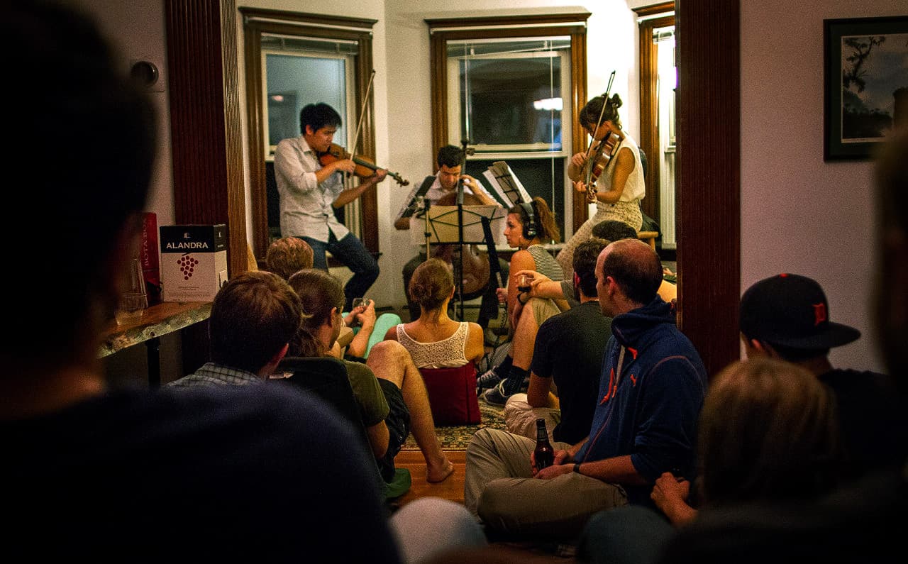 Groupmuse, pictured hosting a classical music party in a Somerville living room, is one of the many classical music organizations getting performances out of symphony halls and into more informal spaces. (Hadley Green for WBUR)