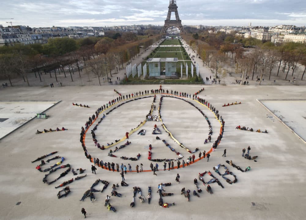 Environmentalist activists form a human chain representing the peace sign and the spelling out &quot;100% renewable,&quot; on the side line of the COP21, United Nations Climate Change Conference near the Eiffel Tower in Paris on Sunday