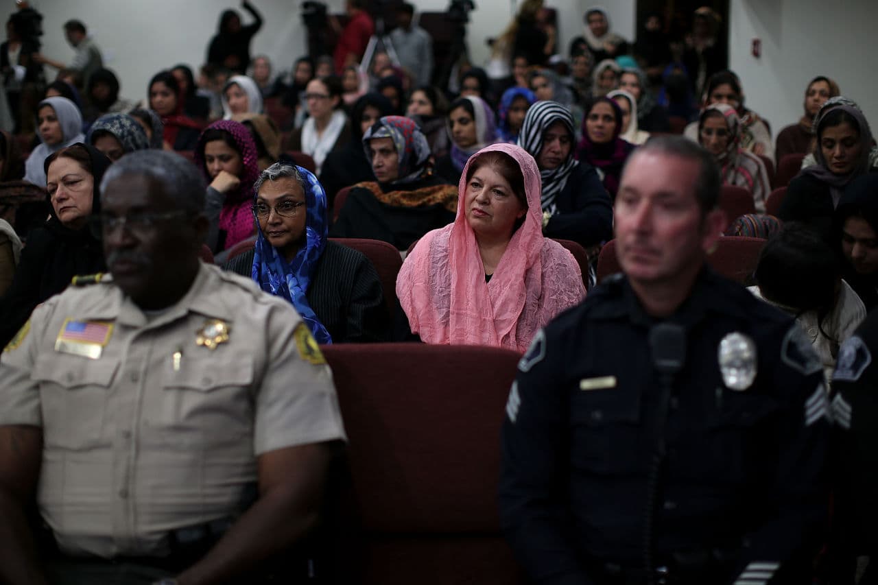 Muslim women sit behind police officers during a prayer vigil at Baitul Hameed Mosque on December 3, 2015 in Chino, California, a day after the mass shooting at the Inland Regional Center in San Bernardino that left at least 14 people dead. (Justin Sullivan/Getty Images)