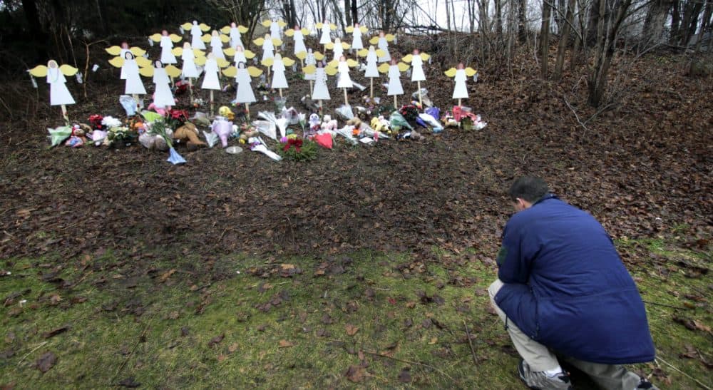 Robert Soltis, of Newtown, Conn., pauses after making the sign of the cross at a memorial to Sandy Hook Elementary School shooting victims in Newtown on Dec. 18, 2012. The massacre of 20 children and 6 adults served a rallying cry for gun-reform advocates. Three years later, the call for reform remains unheeded. (Charles Krupa/AP)
