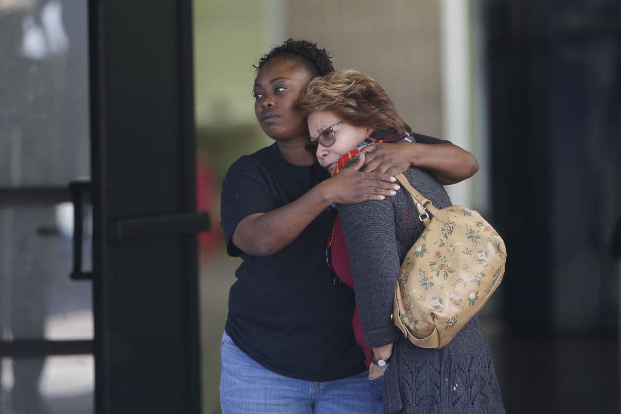 Two women embrace at the community center where family members were gathering to pick up survivors. (Jae C. Hong/AP)