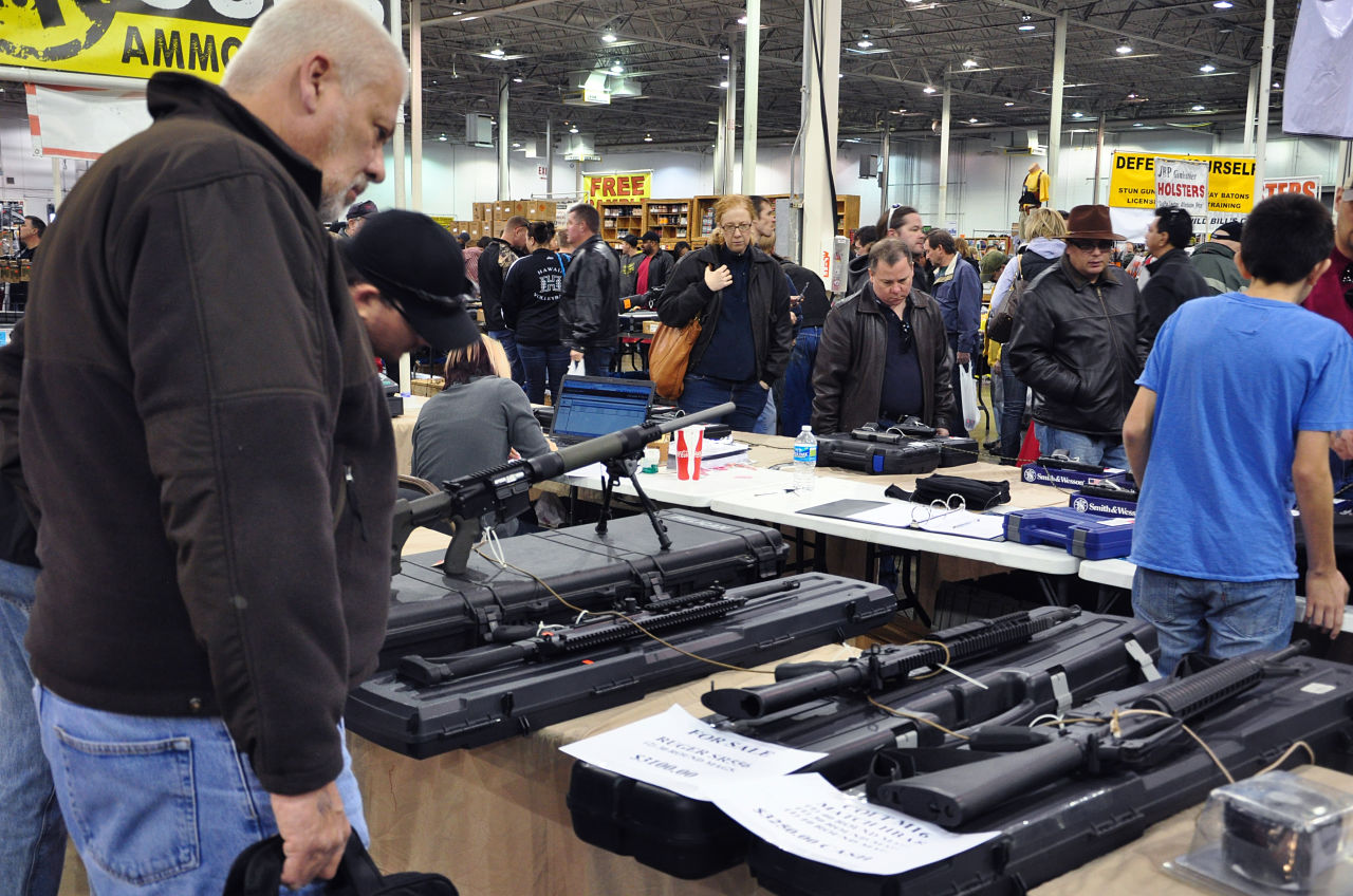 Gun show goers look at various assault-style weapons December 30, 2012 at the Nation's Gun Show in Chantilly, Virginia. Since the Connecticut school shootings, gun sales, particularly assault-style weapons have gone up sharply. AFP PHOTO/Guillaume MEYER (Photo credit should read Guillaume Meyer/AFP/Getty Images)