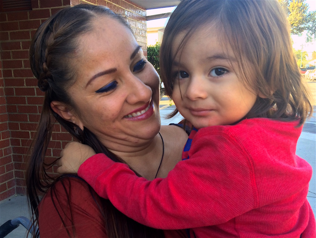 Norwalk mom, Ana Martin, with her 2-year-old son, Sebastian, wait outside a local elementary school to pick up her older children after school. She hopes Sebastian will be able to enroll in preschool when he turns 3. DEEPA FERNANDES / KPCC