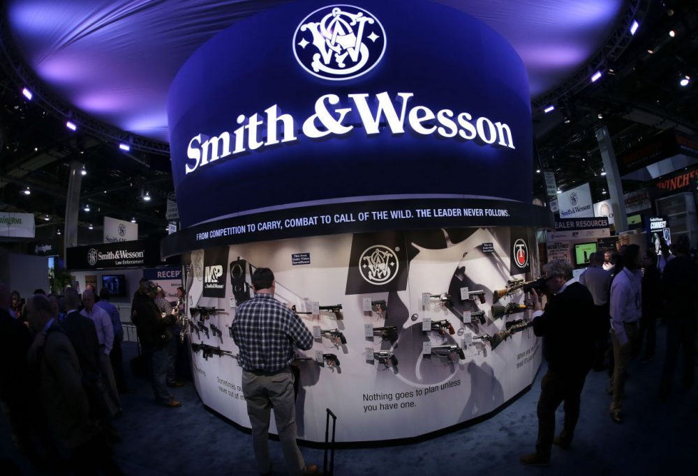 In this 2014 file photo, Las Vegas trade show attendees examine handguns and rifles in the Smith & Wesson display booth. (Julie Jacobson/AP)