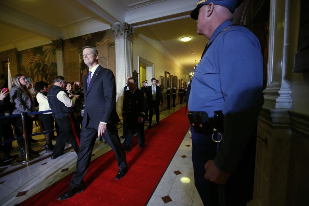 Gov. Charlie Baker, left, walks into the House Chamber to deliver his State of the State address on Thursday. (Michael Dwyer/AP)