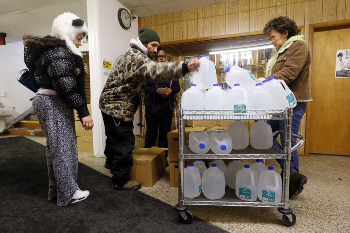 In this Feb. 3, 2015 file photo, Flint residents receive free water being distributed at the Lincoln Park United Methodist Church in Flint, Mich. (AP Photo/Paul Sancya)