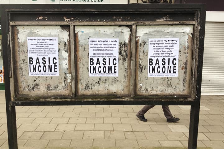 A triptych of signs promoting different aspects of a universal basic income, or UBI, in an unidentified public space in the United Kingdom. (Flickr / Russell Shaw Higgs)