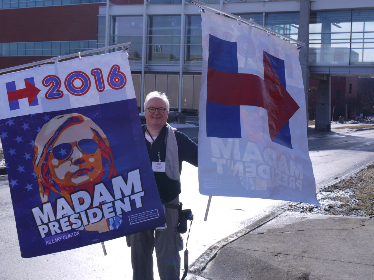 A man holds signs supporting Hillary Clinton for president in Ames, Iowa. (Alex Ashlock/Here &amp; Now)