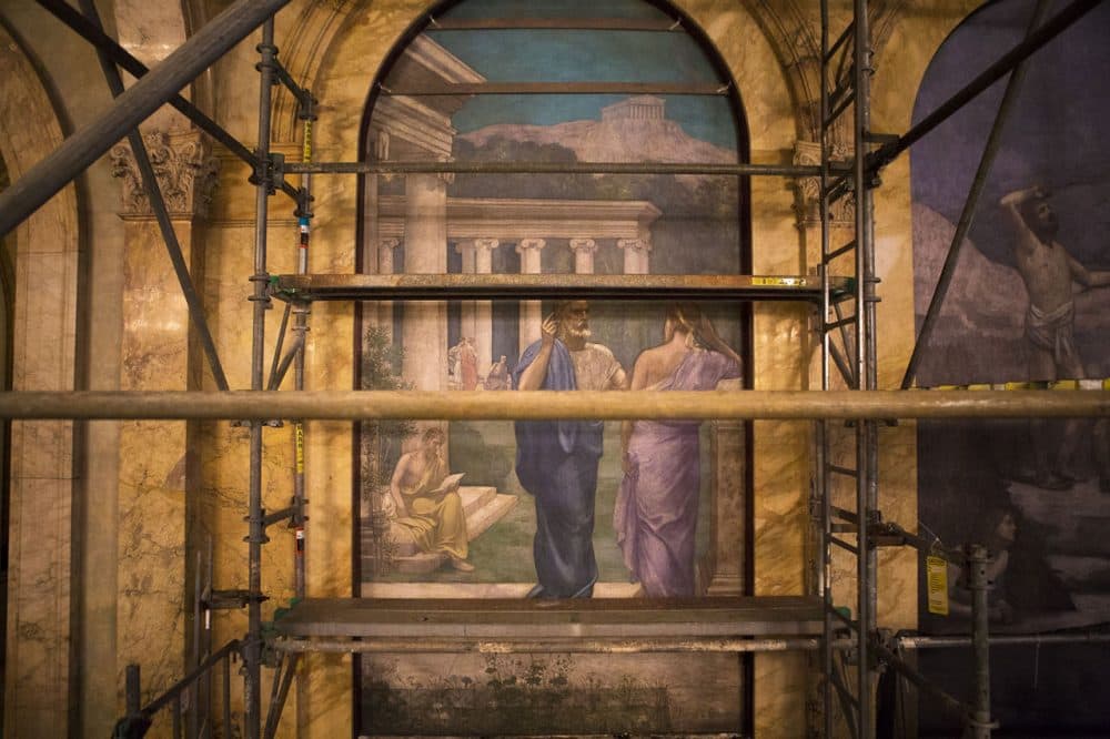 Two robed figures have a conversation in the philosophy mural by 19th-century French muralist Pierre Puvis de Chavannes, seen here behind the scaffolding. (Jesse Costa/WBUR)