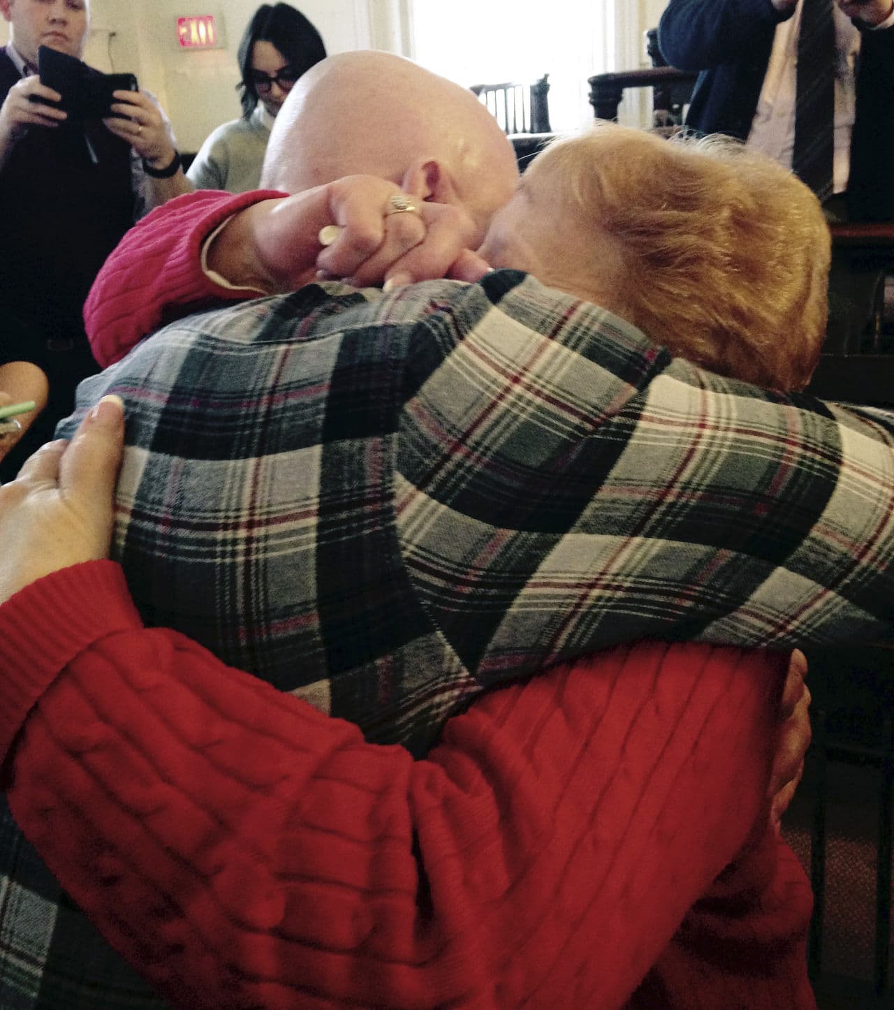 George Perrot, left, hugs his mother Beverly Garrant on Wednesday, after Judge Robert Kane ordered Perrot released from prison. (Denise Lavoie/AP)